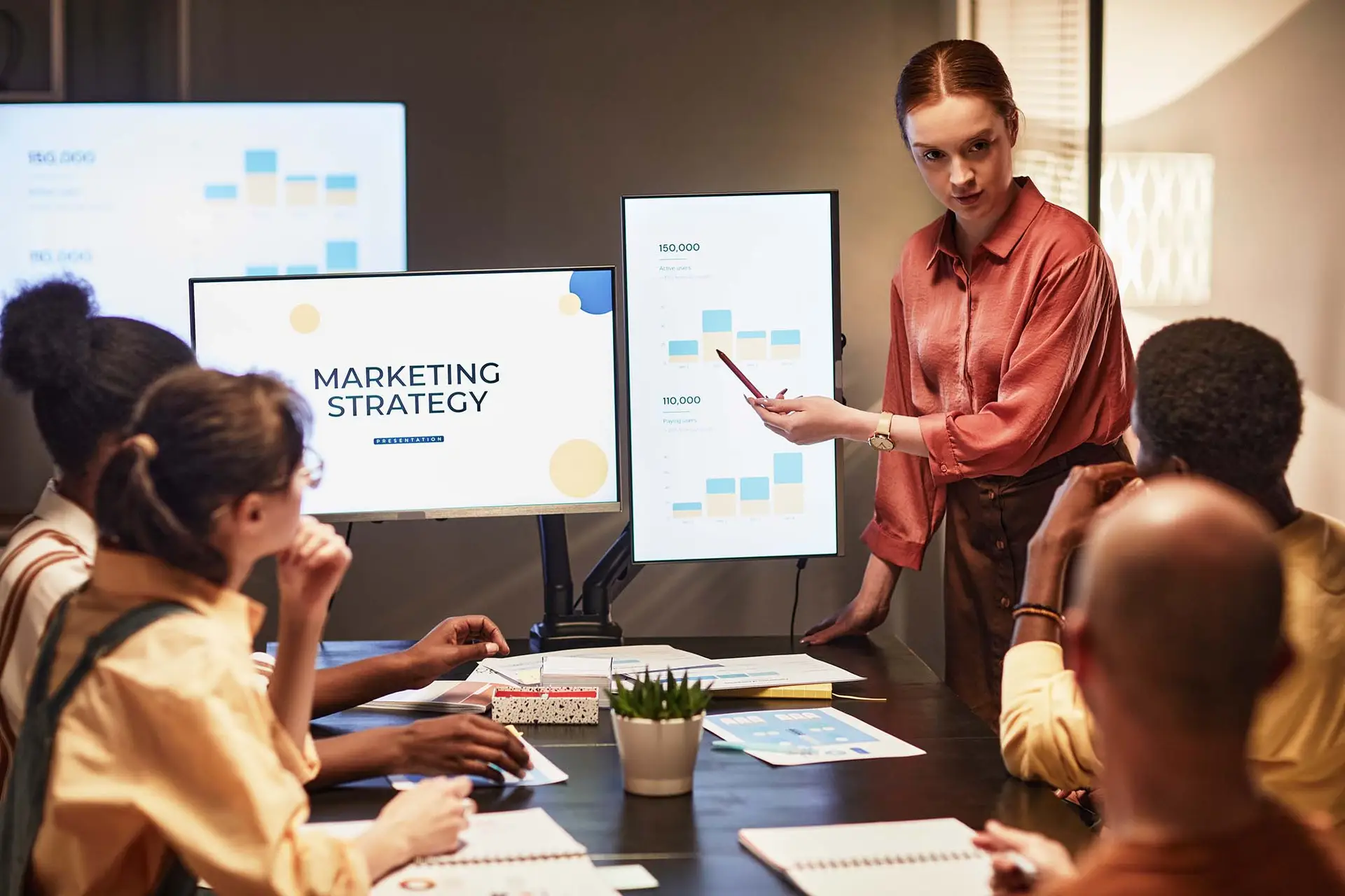 Business team discussing a social media marketing strategy around a laptop